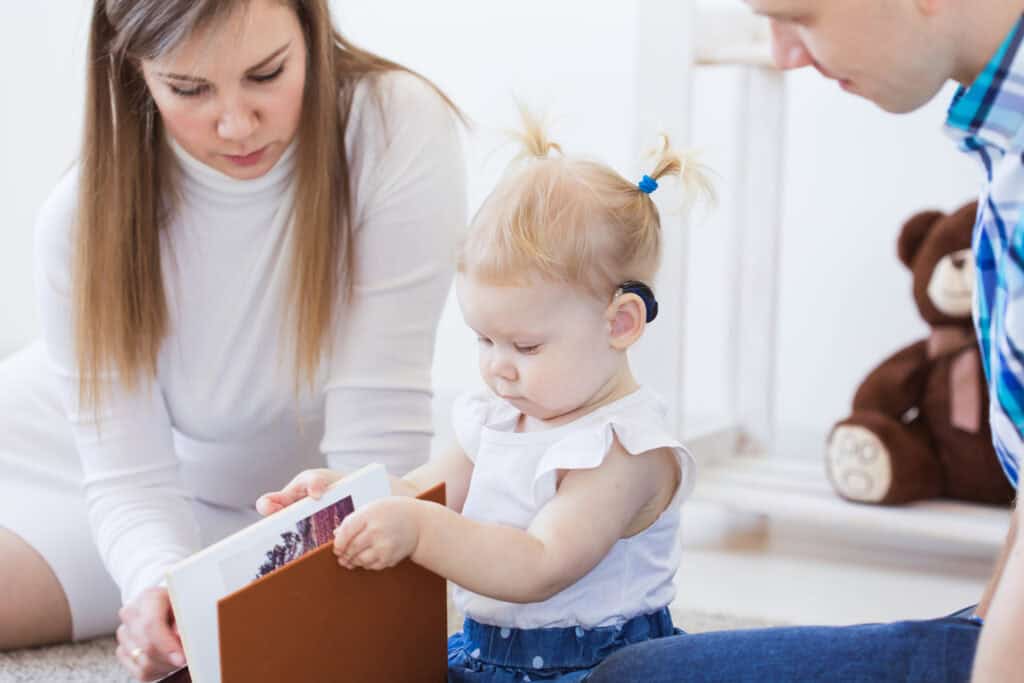 Baby girl wearing a hearing aid. Disabled child, disability and deafness concept.